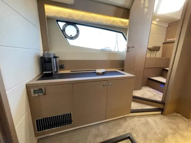 Slide: The Image of Luxurious interior of a 2017 Prestige 500 yacht, featuring modern cabinetry and a porthole window. - 44