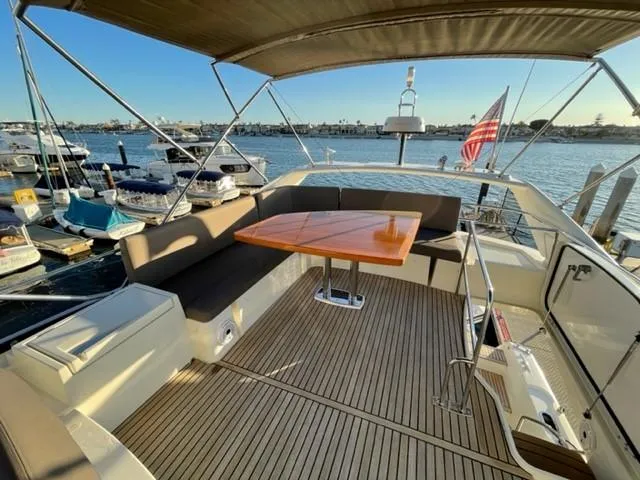 Slide: The Image of Luxurious 2017 Prestige 500 yacht deck with seating, table, and scenic marina view. - 48