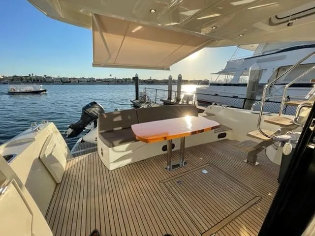 Slide: The Image of Luxurious 2017 Prestige 500 yacht deck with seating, table, and scenic waterfront view. - 5