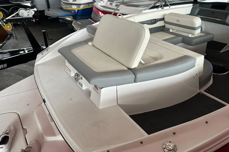 Slide: The Image of 2021 Cobalt CS22 boat interior with cushioned seating in a showroom. - 10