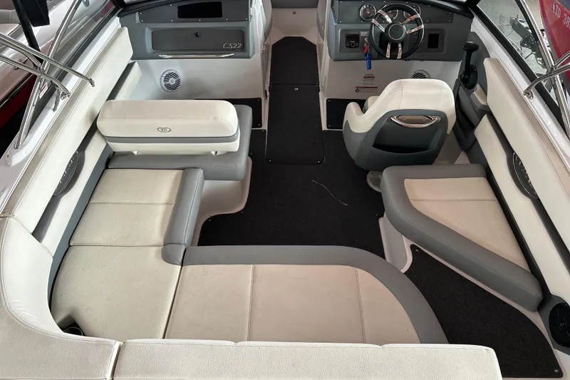 Slide: The Image of 2021 Cobalt CS22 boat interior with white and gray seating, steering wheel, and dashboard. - 11