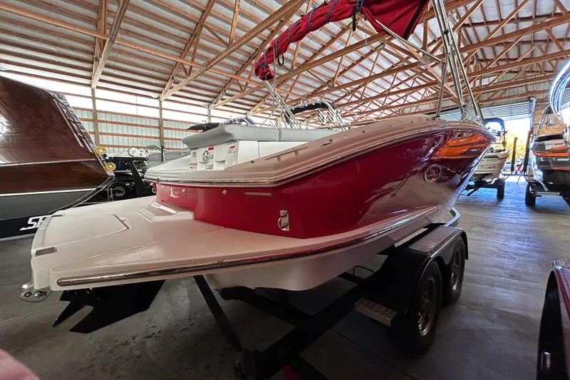 Slide: The Image of 2021 Cobalt CS22 boat in storage, red and white exterior, on a trailer. - 3