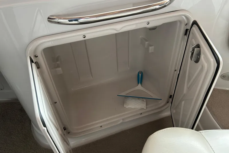 Slide: The Image of Open storage compartment on 2008 Crownline 230 CCR boat with cleaning tool inside. - 12