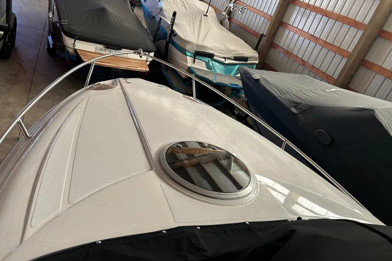 Slide: The Image of 2008 Crownline 230 CCR boat in storage, covered and surrounded by other boats. - 3