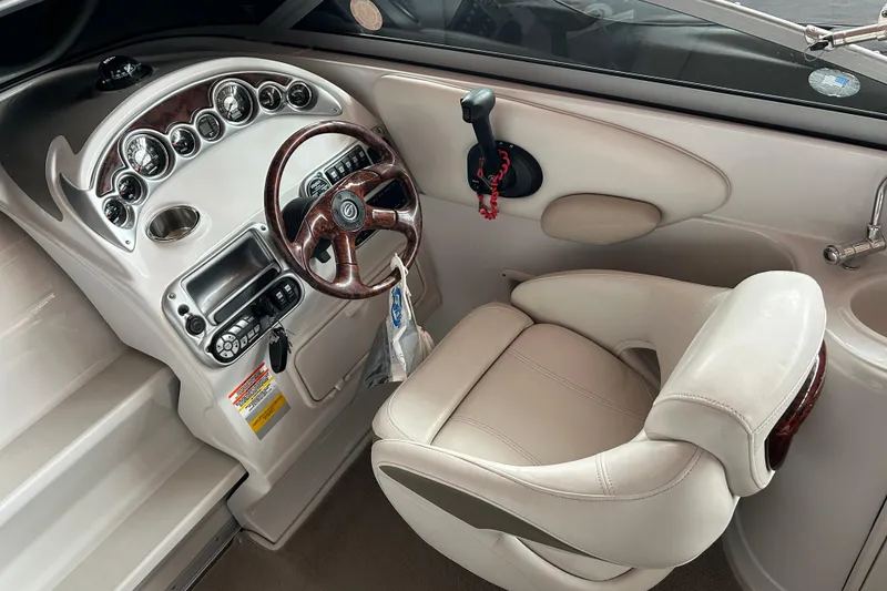 Slide: The Image of 2008 Crownline 230 CCR boat cockpit with steering wheel, gauges, and beige captain's chair. - 6