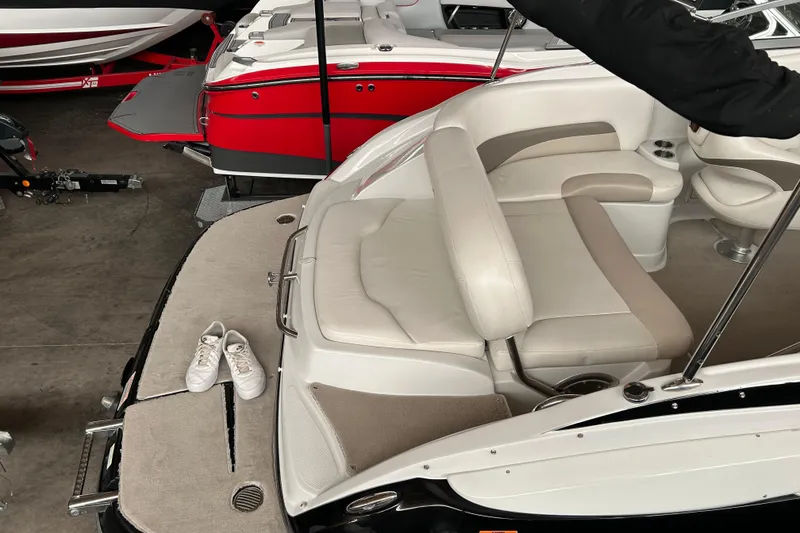 Slide: The Image of 2008 Crownline 230 CCR boat interior with white seating and shoes on the deck. - 9