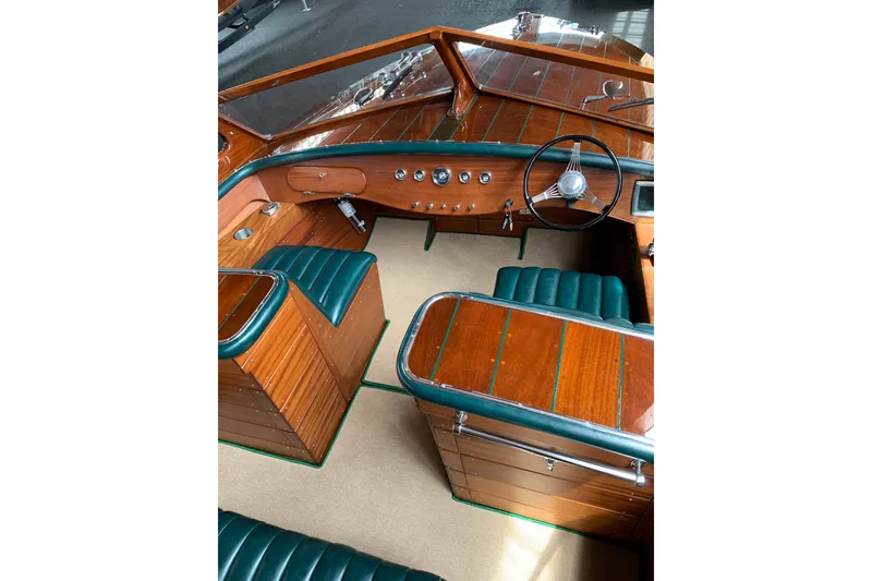 Slide: The Image of Interior of a 2010 StanCraft 27 Lowboy boat with wooden finish and green upholstery. - 10