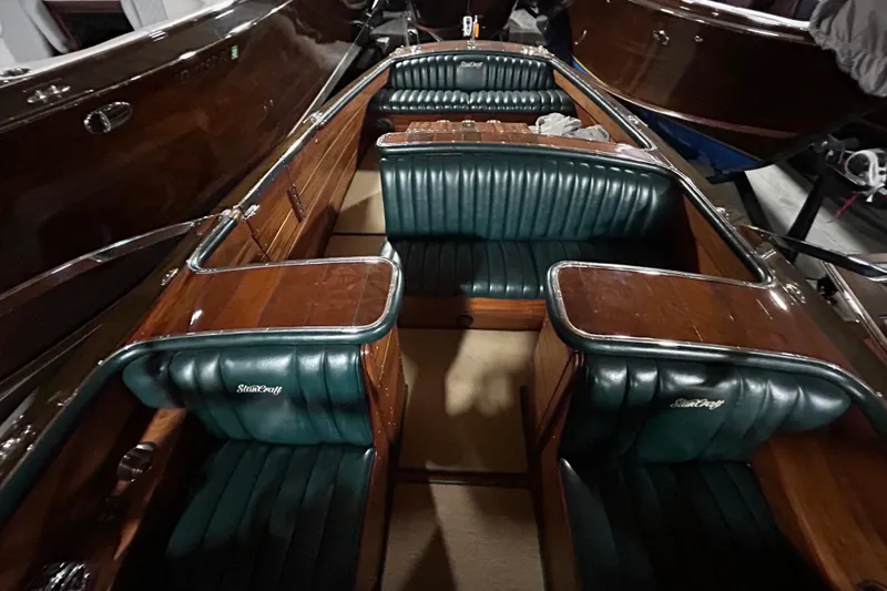 Slide: The Image of 2010 StanCraft 27 Lowboy boat interior with luxurious green leather seating and polished wood finish. - 11