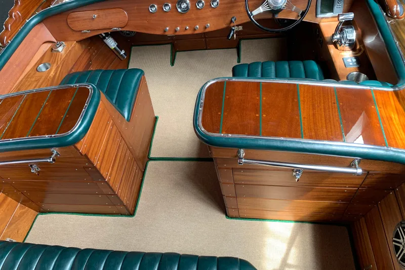 Slide: The Image of Interior of a 2010 StanCraft 27 Lowboy boat with polished wood and green leather seats. - 8
