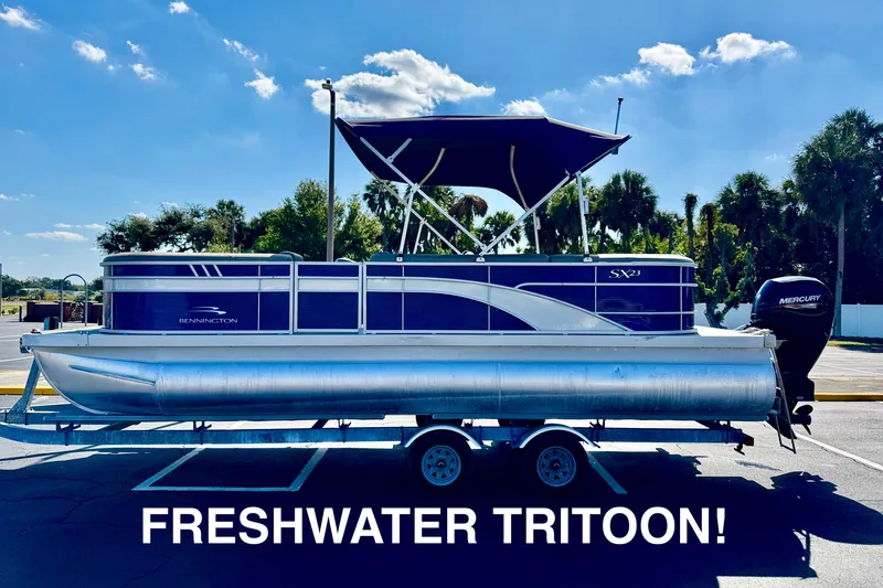 The Image of 2023 Bennington 23 SX tritoon boat on trailer, labeled "Freshwater Tritoon." - 0