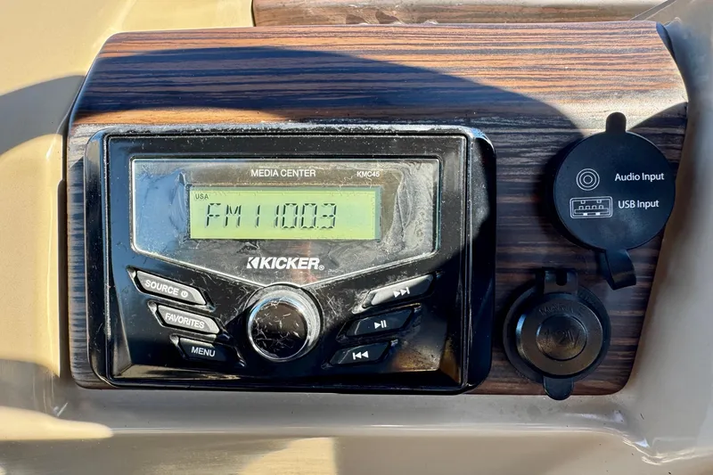 Slide: The Image of Kicker media center in 2023 Bennington 23 SX boat, displaying FM 100.3. - 17