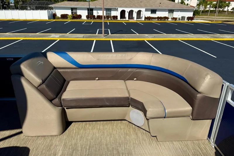 Slide: The Image of 2023 Bennington 23 SX boat seating in a parking lot, showcasing luxurious beige and brown upholstery. - 21