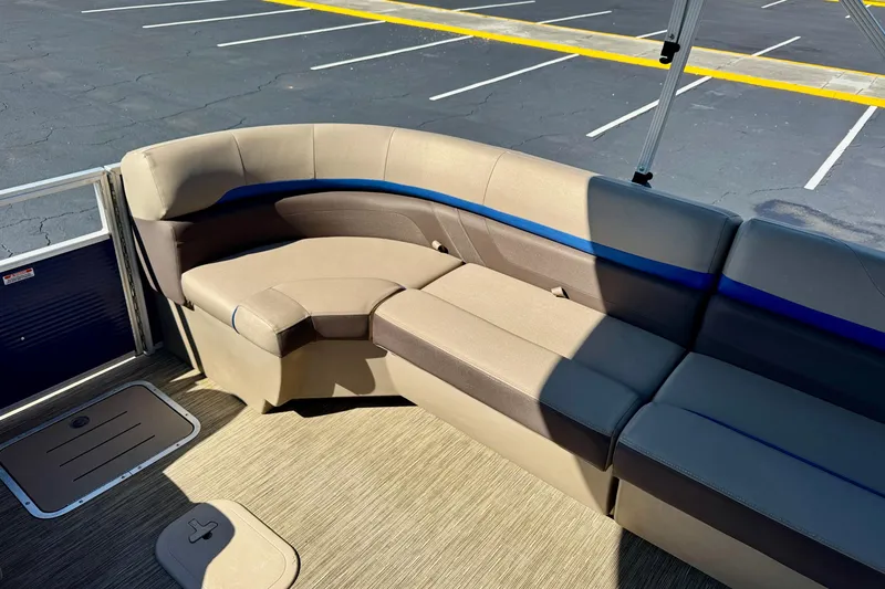 Slide: The Image of 2023 Bennington 23 SX boat interior with beige and blue cushioned seating. - 24