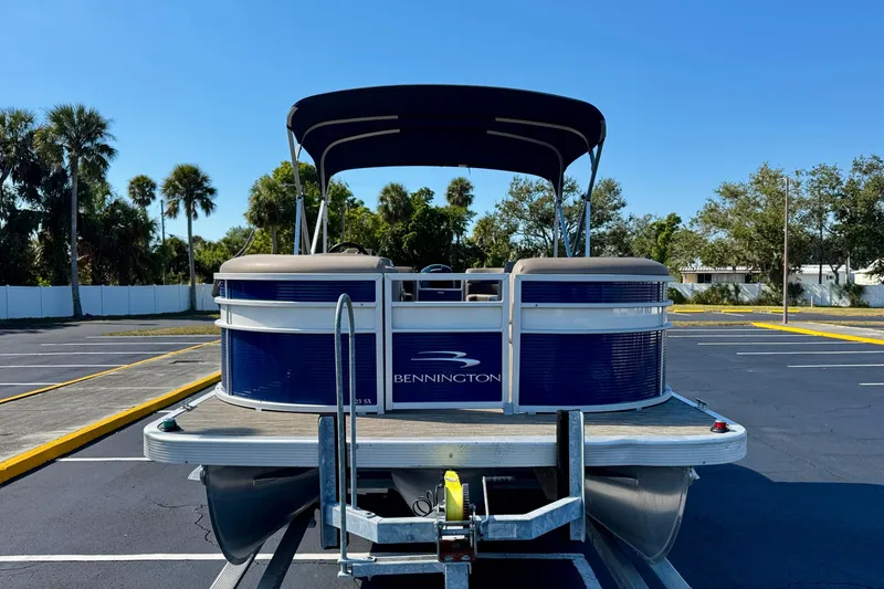 Slide: The Image of 2023 Bennington 23 SX pontoon boat on trailer in sunny parking lot. - 3