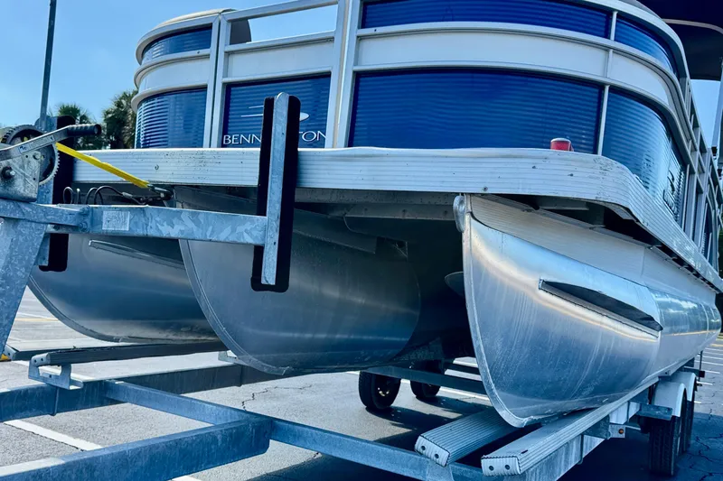Slide: The Image of 2023 Bennington 23 SX pontoon boat on trailer, showcasing sleek aluminum pontoons. - 8