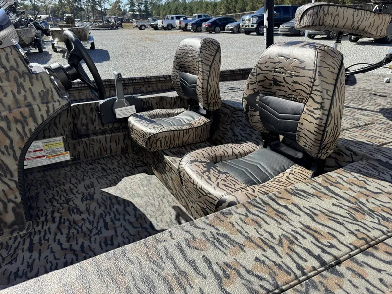 Slide: The Image of 2026 Xpress XP180 boat interior with camouflage seats and steering wheel. - 5
