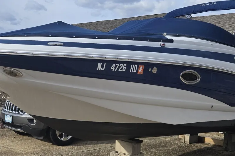 The Image of 2012 Crownline Eclipse E4 boat with blue cover, docked on blocks. - 0