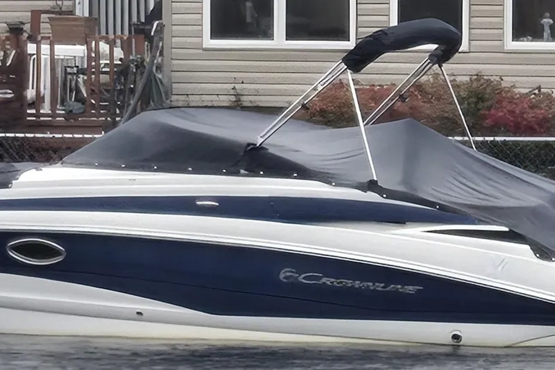 Slide: The Image of 2012 Crownline Eclipse E4 boat with cover, docked near a house. - 1