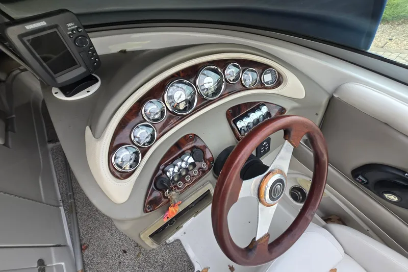 Slide: The Image of 2012 Crownline Eclipse E4 boat dashboard with gauges and wooden steering wheel. - 22