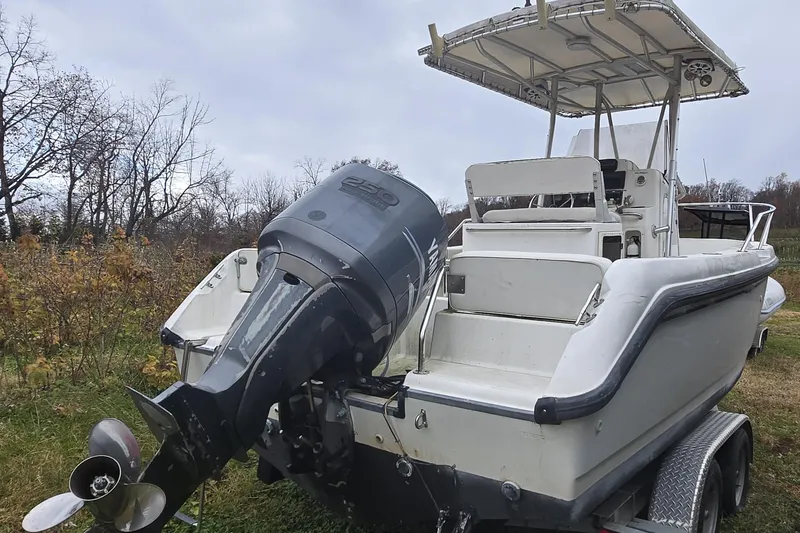 Slide: The Image of 1999 Boston Whaler 21 Outrage boat with canopy, docked in wooded area. - 10