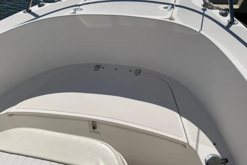 Slide: The Image of 1999 Boston Whaler 21 Outrage boat interior, featuring white seating and storage compartment. - 19