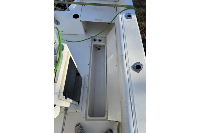 Slide: The Image of 1999 Boston Whaler 21 Outrage boat interior with storage compartment and fishing rod holders. - 28