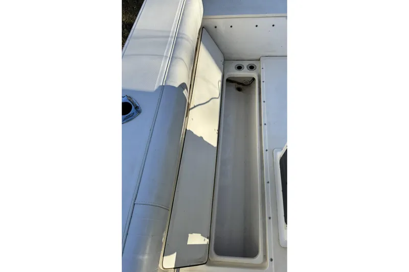 Slide: The Image of 1999 Boston Whaler 21 Outrage boat interior storage compartment and seating area. - 30