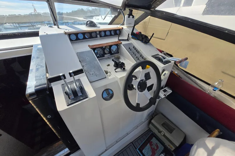 Slide: The Image of 1987 Silverton 34X Express boat helm with steering wheel and control panel. - 10