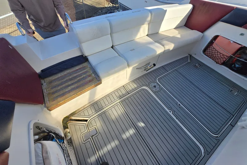 Slide: The Image of 1987 Silverton 34X Express boat interior with white seating and gray flooring. - 2
