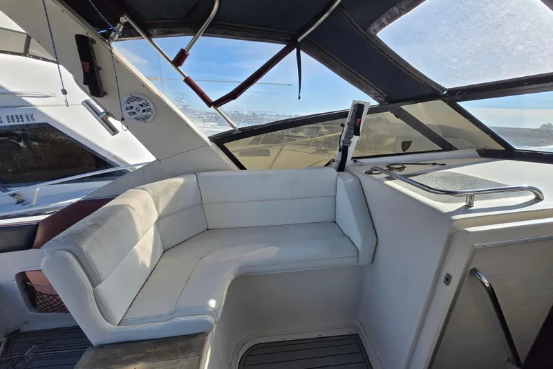 Slide: The Image of 1987 Silverton 34X Express boat interior with white seating and panoramic windows. - 3
