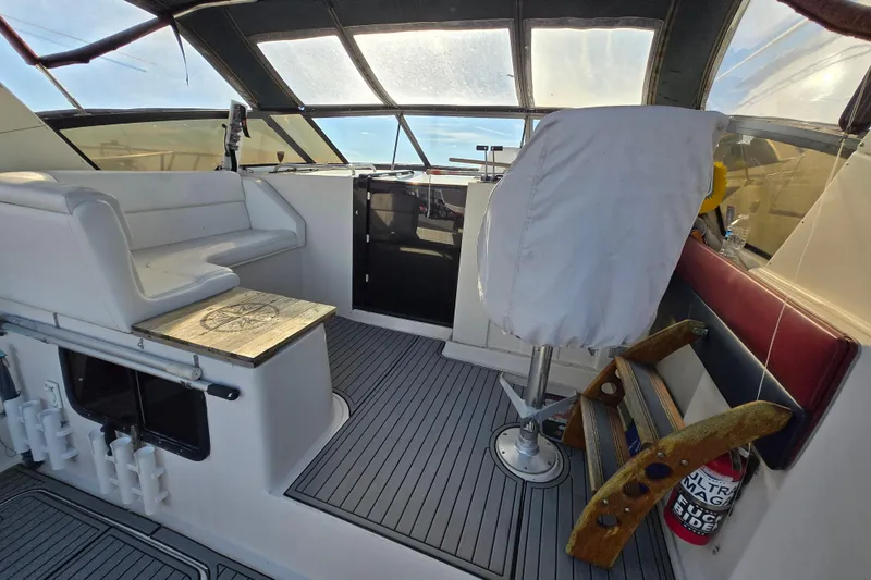 Slide: The Image of 1987 Silverton 34X Express boat interior with seating and helm, featuring a covered captain's chair. - 4