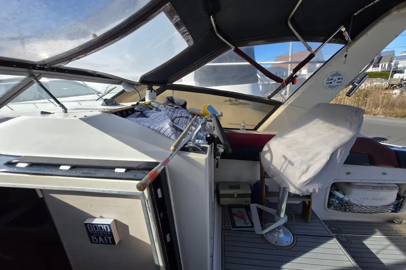 Slide: The Image of 1987 Silverton 34X Express boat interior with covered seating and steering wheel. - 8