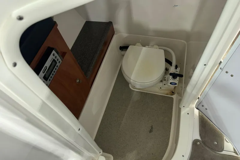 Slide: The Image of 2010 Rinker 296 Captiva Bowrider interior with marine toilet and control panel. - 10