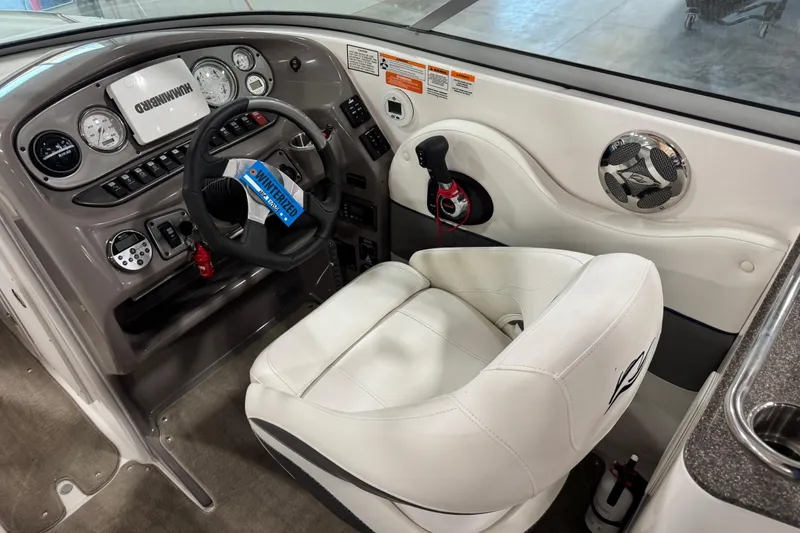 Slide: The Image of 2010 Rinker 296 Captiva Bowrider helm with steering wheel, gauges, and white captain's chair. - 14