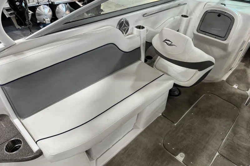 Slide: The Image of 2010 Rinker 296 Captiva Bowrider interior with white seating and steering area. - 15