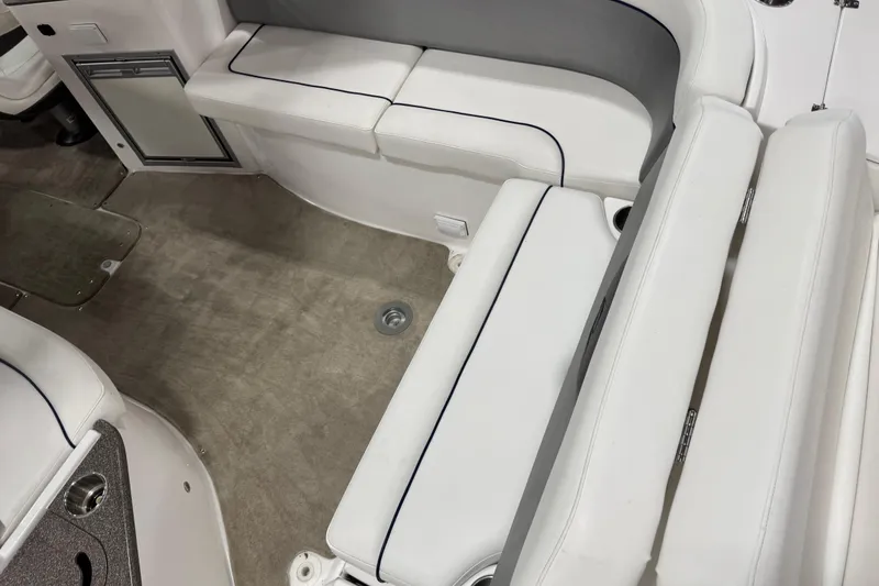 Slide: The Image of 2010 Rinker 296 Captiva Bowrider interior with white seating and carpeted floor. - 16