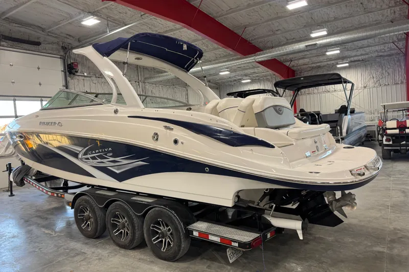 Slide: The Image of 2010 Rinker 296 Captiva Bowrider boat on trailer in indoor storage facility. - 4