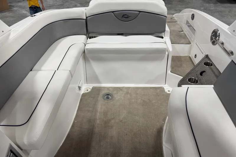 Slide: The Image of 2010 Rinker 296 Captiva Bowrider interior with white and gray seating, cup holders, and carpeted floor. - 8