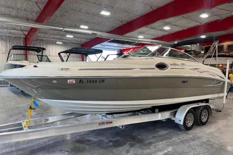 The Image of 2006 Sea Ray 240 Sundeck boat on trailer in indoor storage facility. - 1