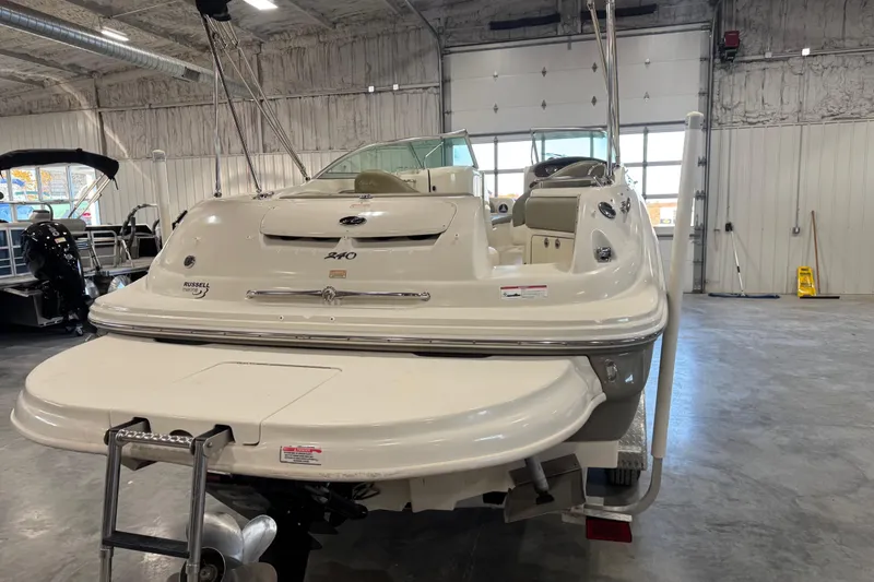 Slide: The Image of 2006 Sea Ray 240 Sundeck boat in a showroom, rear view with swim platform. - 14