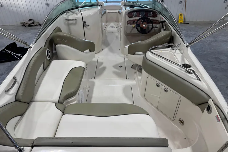 Slide: The Image of 2006 Sea Ray 240 Sundeck interior with white and gray seating, steering wheel, and dashboard. - 5