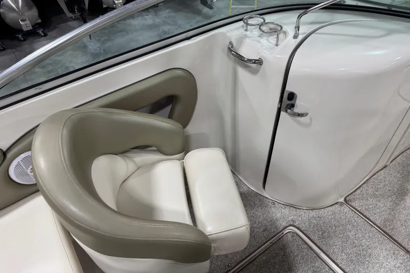 Slide: The Image of 2005 Sea Ray 240 Sundeck interior with cushioned seating and cup holders. - 10