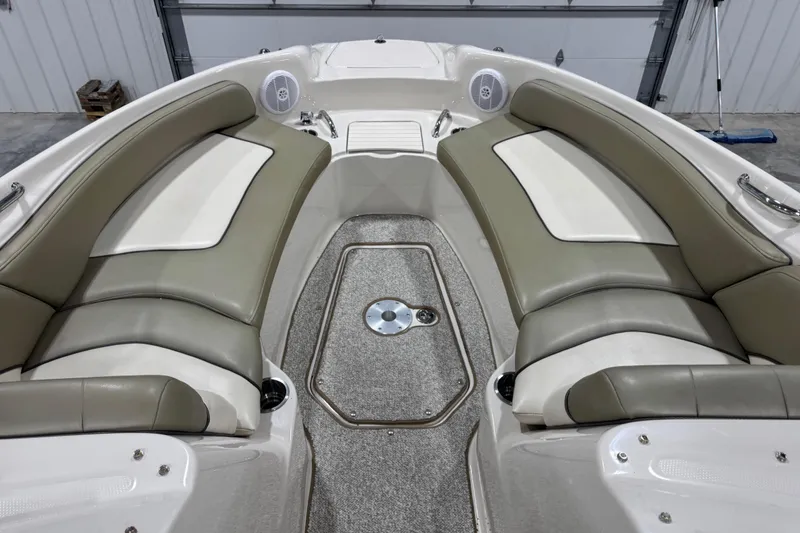 Slide: The Image of 2005 Sea Ray 240 Sundeck interior with beige seating and carpeted floor. - 12