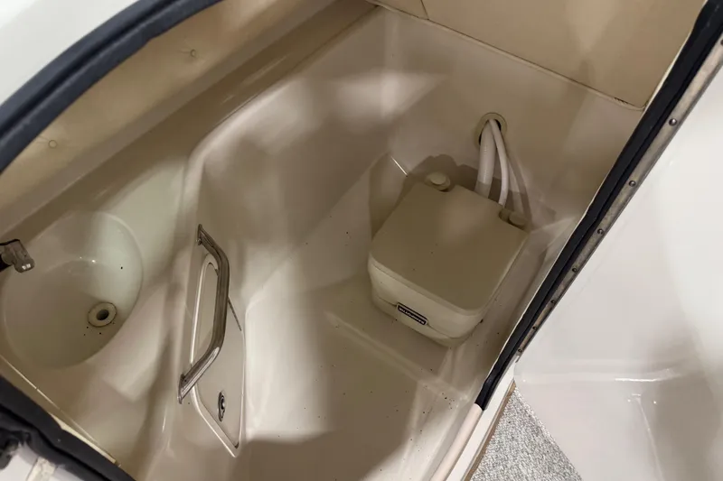 Slide: The Image of 2005 Sea Ray 240 Sundeck interior with compact marine toilet and sink. - 13