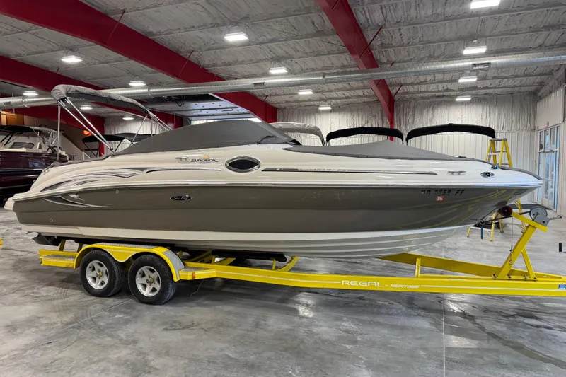 Slide: The Image of 2005 Sea Ray 240 Sundeck boat on yellow trailer in indoor storage facility. - 16