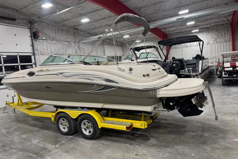 Slide: The Image of 2005 Sea Ray 240 Sundeck boat on yellow trailer in indoor storage facility. - 3