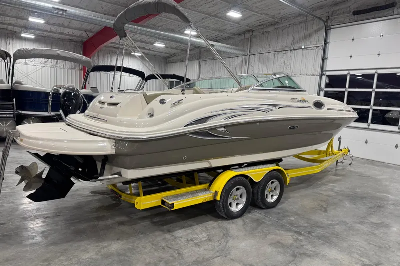 Slide: The Image of 2005 Sea Ray 240 Sundeck boat on yellow trailer in indoor storage facility. - 4
