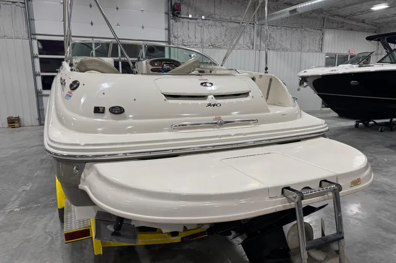 Slide: The Image of 2005 Sea Ray 240 Sundeck boat in a garage, rear view with swim platform. - 5