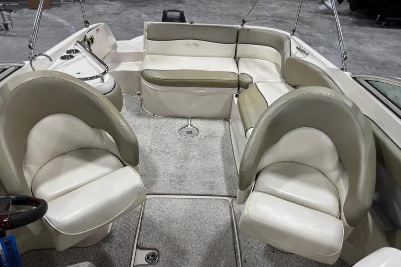 Slide: The Image of 2005 Sea Ray 240 Sundeck interior with plush seating and carpeted flooring. - 8
