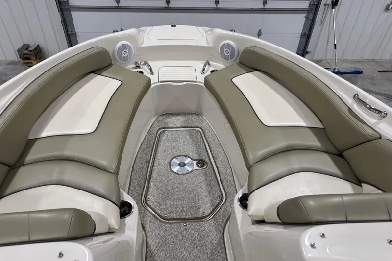 Slide: The Image of 2005 Sea Ray 240 Sundeck interior with beige seating and carpeted floor. - 9